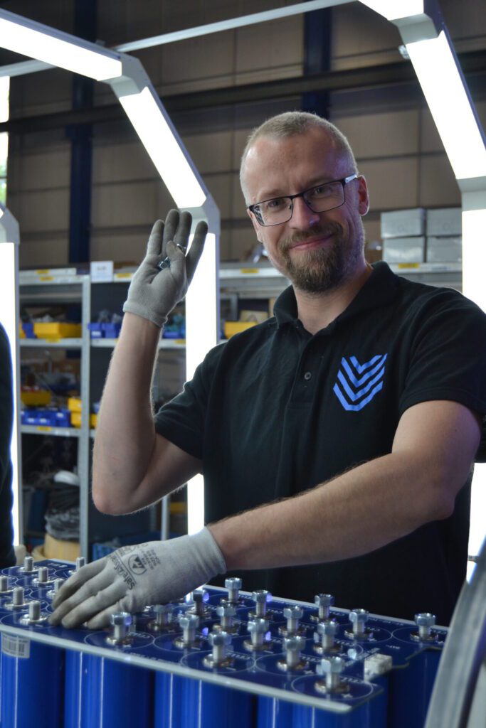 Lukasz waves his hand while building a supertitan battery